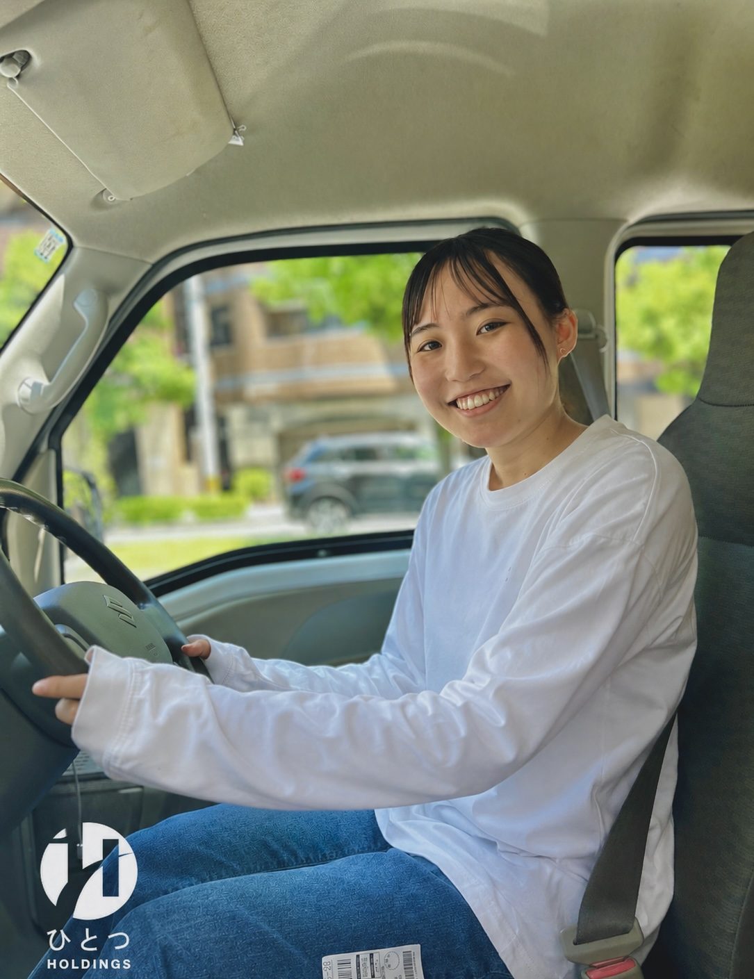 運転席で笑顔を見せるスタッフ